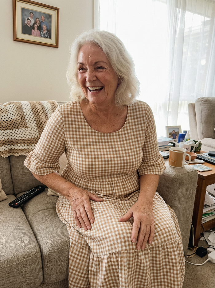 Woman wearing the Iris gingham midi dress on a sofa
