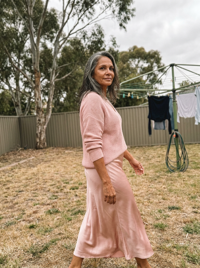 Woman wearing the Luciana satin skirt set in a backyard